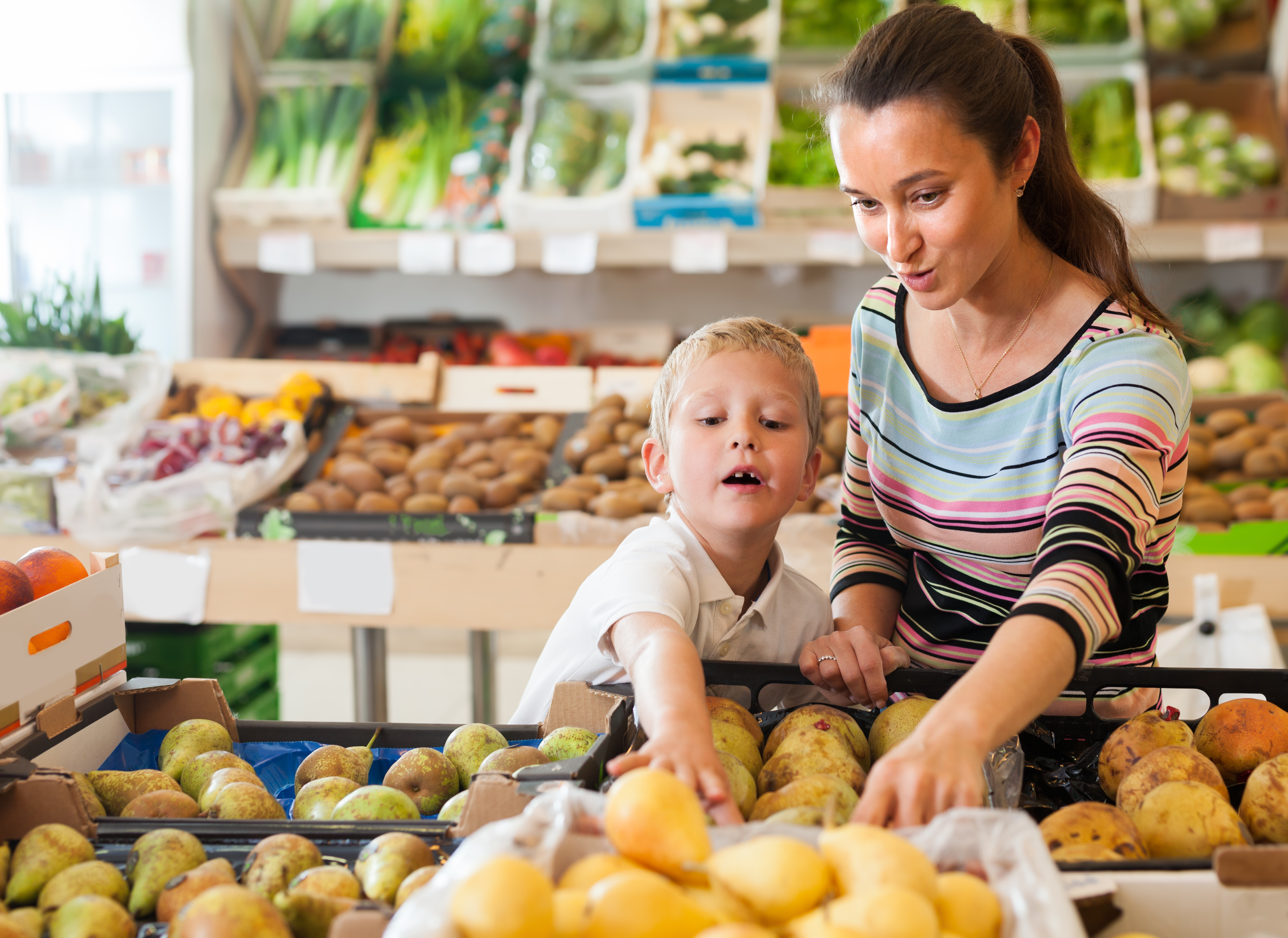 women and child in grocery picking out produce